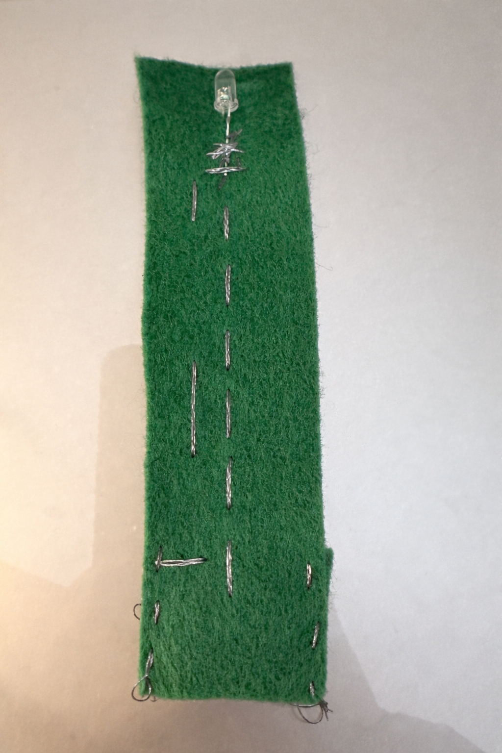 I placed the LED on two sides based on polarity. The battery was also separated into positive and negative, and I sewed conductive thread from the battery to the LED according to their charges.