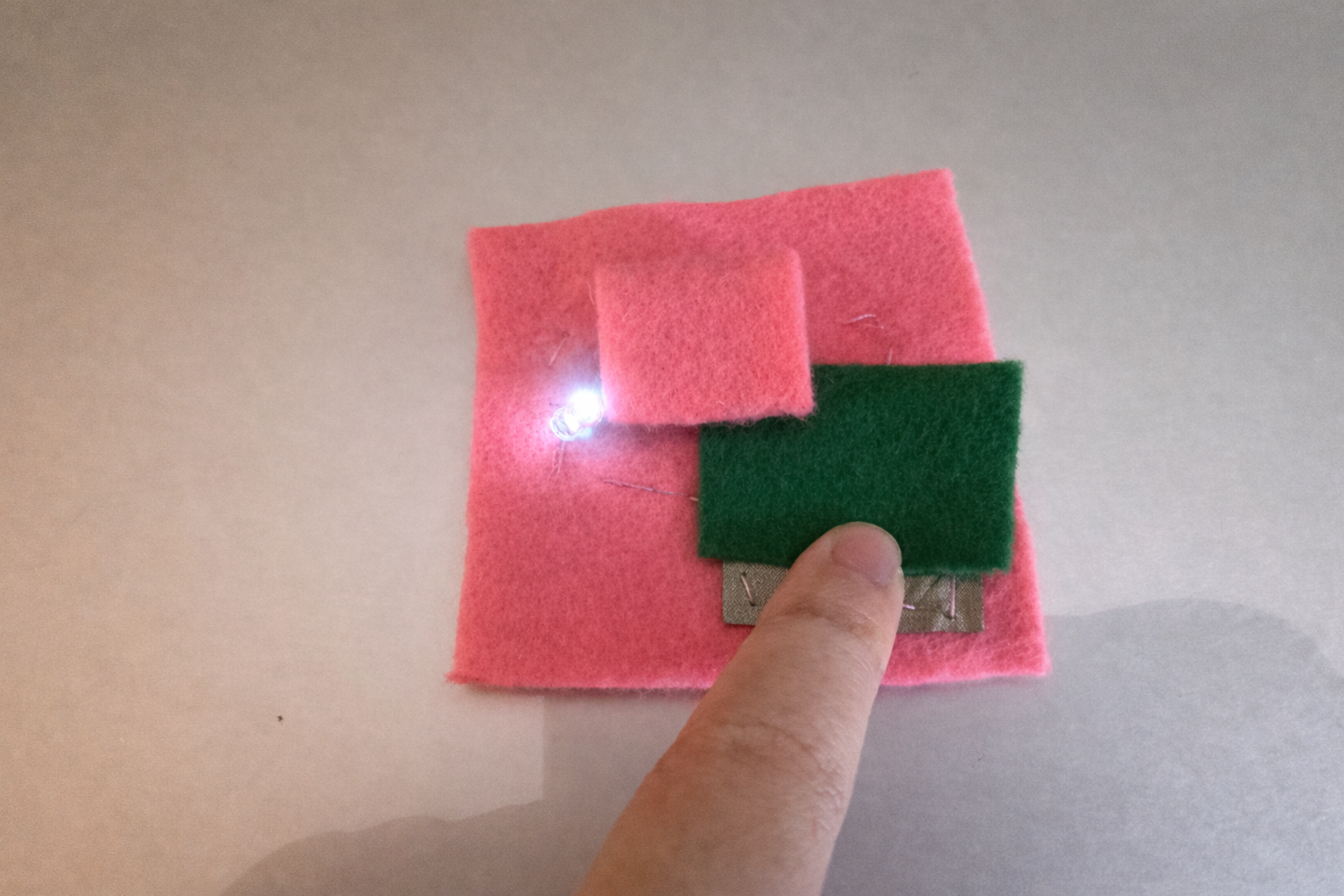 The LED lit up very well. The combination of conductive fabric and conductive thread worked successfully.