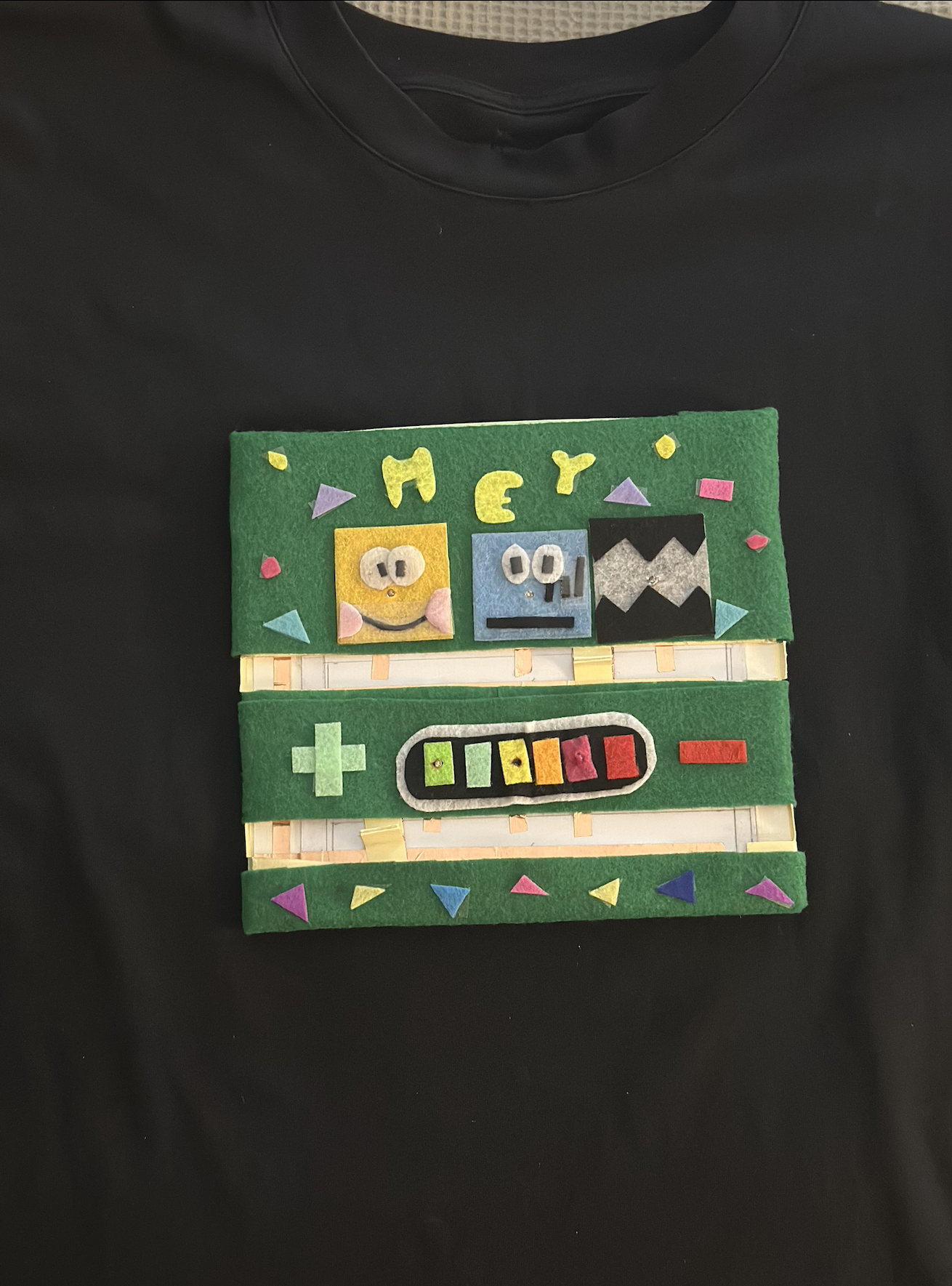 I attached the finished felt badge to a black T shirt with two Velcro strips so it stays secure, sits flat on the body, and can be removed anytime without damaging the shirt.